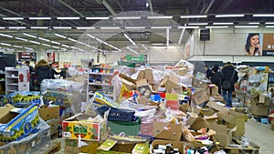 Bankruptcy of supermarket. Clutter, trash and scattered goods on dirty floor in the store. Mess, huge piles of cardboard boxes. Re