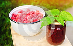 Banks with fragrant homemade raspberry jam in the garden. summer harvest. sweet food. food stock for the winter. countryside, outd