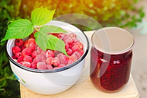 Banks with fragrant homemade raspberry jam in the garden. summer harvest. sweet food. food stock for the winter. countryside, outd