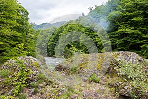 mountain river swift current, whirlpools in the flow of water in a granite canyon photo