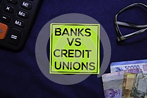 Banks Vs Credit Unions text on sticky notes isolated on office desk. photo