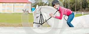 A sweet girl riding a white horse, an athlete engaged in equestrian sports, a girl hugs and kisses a horse.