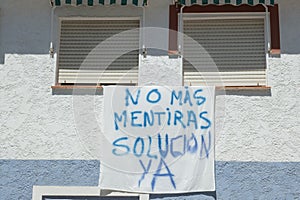 Banner on building wall with spanish words No mas mentiras, solucion YA. People protest, disagreement with local photo