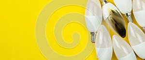 Banner, burned LED light bulb after fire, electrical short circuit concept. Home safety. Top view, copy space, yellow