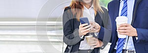 Banner Businessman Businesswoman drinking coffee in town using smartphone outside office city. Panorama Hands holding take away