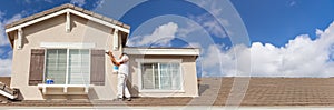 Banner of Busy House Painter Painting the Trim And Shutters of A Home