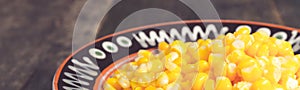 Banner of Canned corn in a brown bowl on wooden background