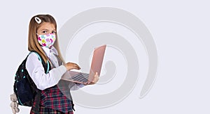 Banner. Caucasian girl and new learning norms during a pandemic. Schoolgirl in a reusable mask and with a laptop