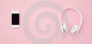 Banner with the cell phone and headphones over the pink background. Music, entertainement, online playlists