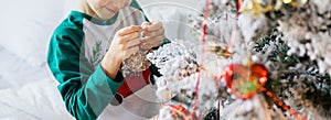 Banner Child decorates Christmas tree copy space mockup. The boy is holding a Christmas toy. Morning before christmas at