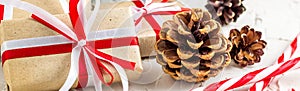 Banner of Christmas or New Year decorations background with pine cones, fir branches, gift boxes, and candy canes