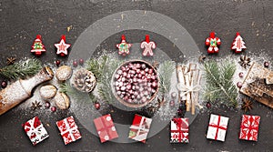 Banner with concept Christmas and New Year. Ingredients for baking, Christmas tree decorations and gift boxes on a dark