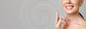 Banner. Cropped portrait middle aged woman with cosmetic cream on finger. Copy space for ad