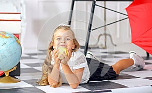 Banner with a cute caucasian girl in a white blouse and black skirt lying with an apple