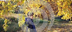 Banner cute teenager in blu jacket on the background of autumn leaves.Autumn background. Copy space