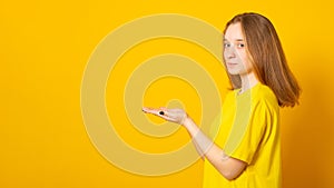 Banner. Cute teenager girl holds something in the palm. Young girl is holding something in her hand copy space for advertising