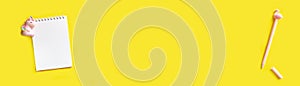 Banner. Cute unicorn near a notepad on a spiral with a pink pen. Top view with copy space, flat lay on yellow background