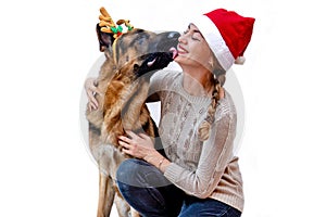 Banner. Dog with deer antlers kisses girl in Santa hat. Woman and pet celebrates new year, Christmas. Greeting card with German