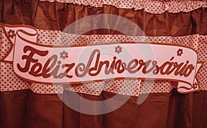Banner Feliz Aniversario on a red curtain photo