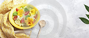 Banner with Fresh summer salad with edible flowers nasturtium, borage flowers in a bowl. Web banner, copy space. Vegan food