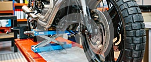 Banner of front wheel tyre and brake disk of custom motorbike on workshop