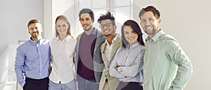 Banner with a group portrait of a happy diverse business team standing in the office