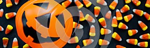 Banner with Halloween Background Candy corn candies, pumpkin basket. Traditional sweet Treats. Copy space