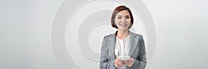 Banner of a happy asian businesswoman holding mobile phone isolated over white background