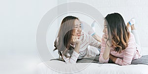 Banner happy Lesbian couple homosexual happiness lifestyle on bed in cozy home bedroom. Two young best friend talk, hug, dance