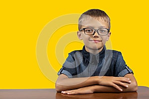 Banner happy smiling boy with glasses black shirt on yellow background Portrait of a 7 year old boy