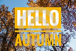 Banner hello autumn. New month. Greeting card. Golden autumn. Autumn in the park. The text in the photo. Trees in the autumn park