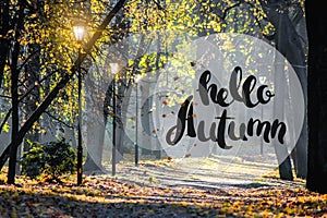 Banner hello autumn. New month. Greeting card. Golden autumn. Autumn in the park. The text in the photo. Trees in the autumn park