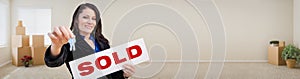 Banner of Hispanic Woman Inside Room with Boxes Holding House Keys and Sold For Sale Real Estate Sign.