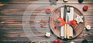 Banner holiday composition of Christmas dinner on wooden background. Top view of plate, utensil and festive decorations. New Year