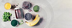 Banner of ingredients for heavy metals detox smoothie. Bilberry, barley grass, spirulina, orange juice, dulse and cilantro on gray