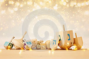 Banner of jewish holiday Hanukkah with wooden dreidels & x28;spinning top& x29; over glitter shiny background.