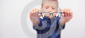 Banner little boy with glasses correcting myopia close-up portrait Ophthalmology problem selective focus