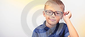 Banner little boy with glasses correcting myopia close-up portrait Ophthalmology problem selective focus