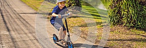 BANNER, LONG FORMAT Child on kick scooter in park. Kids learn to skate roller board. Little boy skating on sunny summer