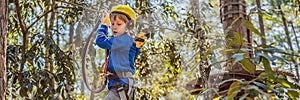 BANNER, LONG FORMAT Happy child in a helmet, healthy teenager school boy enjoying activity in a climbing adventure park