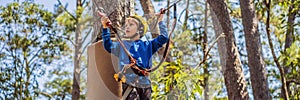 BANNER, LONG FORMAT Happy child in a helmet, healthy teenager school boy enjoying activity in a climbing adventure park