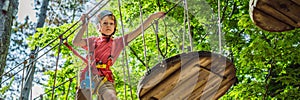 BANNER, LONG FORMAT Happy child in a helmet, healthy teenager school boy enjoying activity in a climbing adventure park