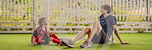 BANNER, LONG FORMAT Little cute kid boy in red football uniform and his trainer or father playing soccer, football on