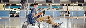 BANNER, LONG FORMAT Man in mask at empty airport at check in in coronavirus quarantine isolation, returning home, flight