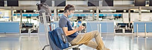 BANNER, LONG FORMAT Man in mask at empty airport at check in in coronavirus quarantine isolation, returning home, flight