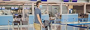 BANNER, LONG FORMAT Man in mask at empty airport at check in in coronavirus quarantine isolation, returning home, flight