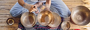 BANNER, LONG FORMAT Nepal Buddha copper singing bowl at spa salon. Young beautiful woman doing massage therapy singing