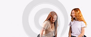 Banner,long format. The pastime of two red-haired girlfriends. Girls chat and smile on a gray background.