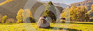 BANNER, LONG FORMAT Scene of sunset or sunrise on the field with haystacks in Autumn season. Rural landscape with cloudy