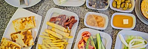 BANNER, LONG FORMAT Turkish breakfast table. Pastries, vegetables, greens, olives, cheeses, fried eggs, spices, jams